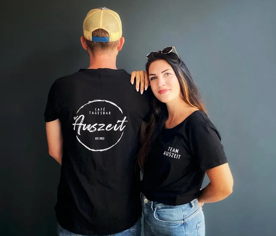 Mann und Frau in schwarzen Shirts mit Café-Auszeit-Aufdruck