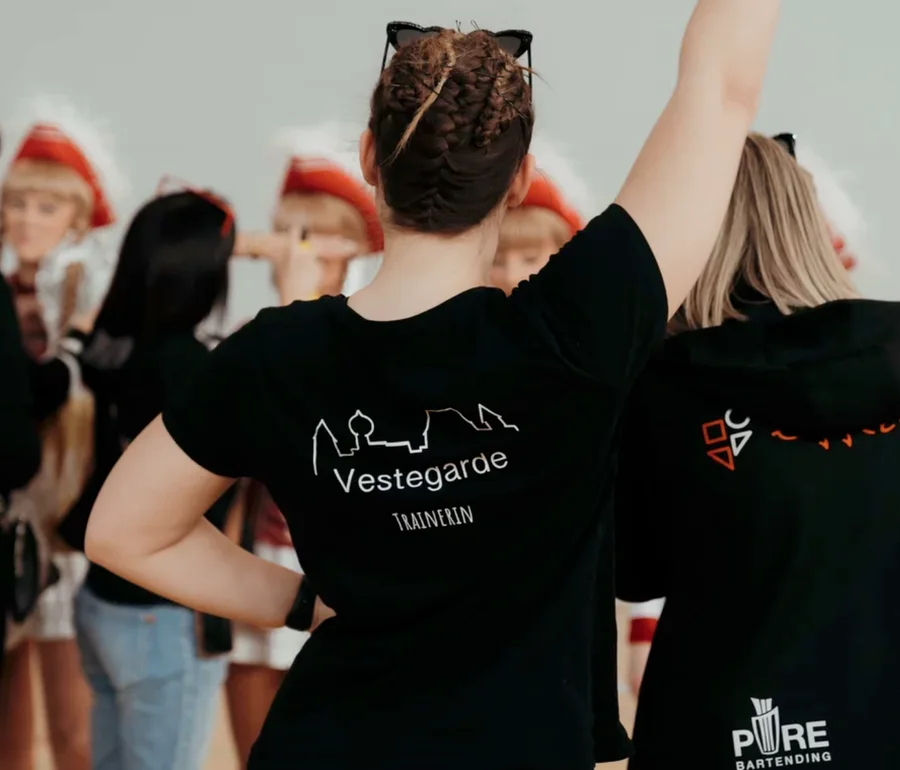 Trainerin und Helferinnen in individuell bedruckter Teamkleidung bei einer Veranstaltung